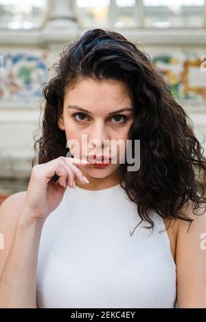 Primo piano ritratto di una giovane donna seria con top bianco Foto Stock