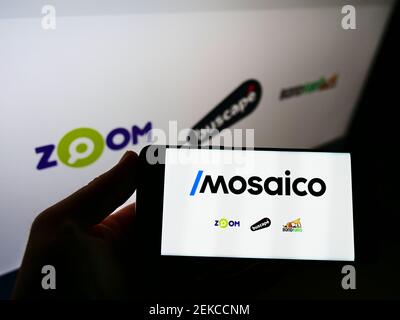 Persona titolare di cellulare con logo della società brasiliana di e-commerce Mosaico tecnologia sullo schermo davanti alla pagina web. Mettere a fuoco il display del telefono. Foto Stock