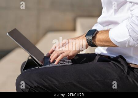 Uomo d'affari che utilizza un tablet digitale mentre si è seduti all'aperto Foto Stock