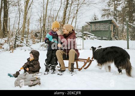 Madre che nutre la figlia durante il fine settimana con la famiglia durante l'inverno nella neve Foto Stock