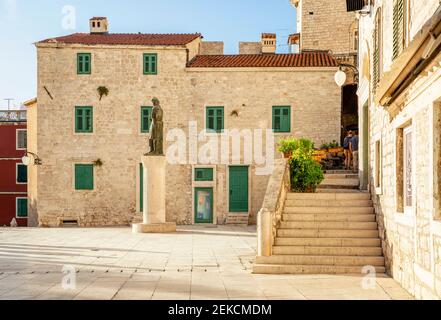 Croazia, Sibenik-Knin County, Sibenik, passi che portano alla costruzione in piedi sulla piazza Trg Republike Hrvatske con la statua sullo sfondo Foto Stock