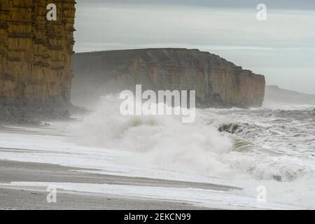 West Bay, Dorset, Regno Unito. 23 febbraio 2021. Regno Unito Meteo. I mari accidentati si schiantano sulla spiaggia di West Bay a Dorset in un pomeriggio colto con forti venti raffazzonati. Picture Credit: Graham Hunt/Alamy Live News Foto Stock