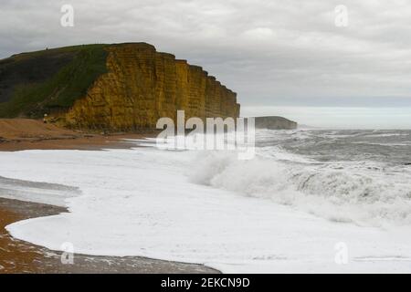 West Bay, Dorset, Regno Unito. 23 febbraio 2021. Regno Unito Meteo. I mari accidentati si schiantano sulla spiaggia di West Bay a Dorset in un pomeriggio colto con forti venti raffazzonati. Picture Credit: Graham Hunt/Alamy Live News Foto Stock