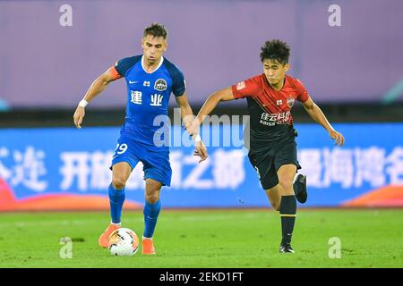 Il calciatore brasiliano Olivio da Rosa, conosciuto anche come Ivo, di Henan Jianye F.C., a sinistra, protegge la palla durante la quarta partita della Super League Cinese 2020 (CSL) contro Shenzhen F.C., città di Dalian, provincia di Liaoning della Cina nordorientale, 10 agosto 2020. Shenzhen F.C. fu sconfitto da Henan Jianye F.C. con 1-2.