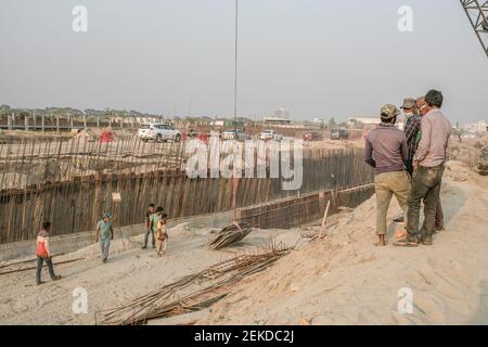 Dhaka, Bangladesh. 22 Feb 2021. Lavoratori che lavorano attraverso una strada polverosa e trafficata a Dhaka. Il Bangladesh, uno dei paesi più densamente popolati del mondo, ha lottato per lungo tempo contro l’inquinamento da polvere, mentre Dhaka continua ad essere classificato tra le città più inquinate. Credit: SOPA Images Limited/Alamy Live News Foto Stock