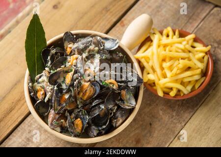 Cozze scozzesi coltivate a corda acquistate da un supermercato Waitrose che sono state cotte e aromatizzate con burro, pepe, crema, bayl eaves, timo, onio Foto Stock