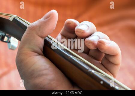 Il chitarrista chiama le dita con la tastiera acustica della chitarra Foto Stock