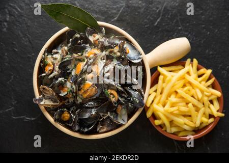 Cozze scozzesi coltivate a corda acquistate da un supermercato Waitrose che sono state cotte e aromatizzate con burro, pepe, crema, foglie di alloro, timo, onio Foto Stock