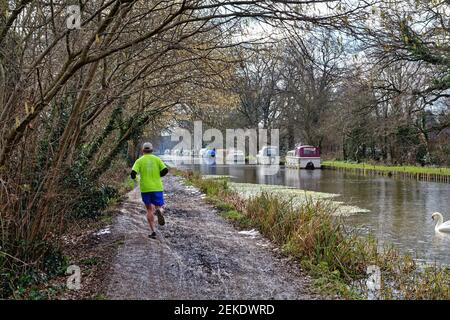 Vista posteriore di un uomo di mezza età che corre sul sentiero Vicino al canale di navigazione del fiume Wey a New Haw Surrey Inghilterra Regno Unito Foto Stock