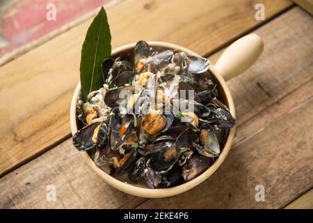 Cozze scozzesi coltivate a corda acquistate da un supermercato Waitrose che sono state cotte e aromatizzate con burro, pepe, crema, foglie di bayleaves, timo, cipolla Foto Stock