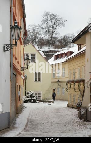 Neve coperta pittoresca strada Nový Svět (New World Street) nel quartiere di Hradčany a Praga, Repubblica Ceca. Foto Stock