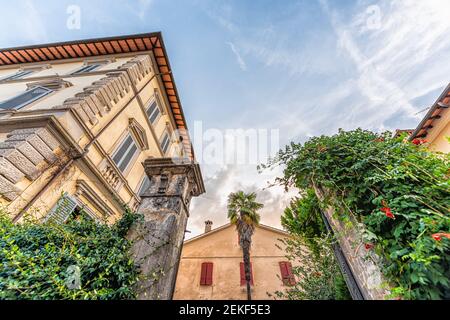 Chiusi, Italia strada in piccolo borgo storico medievale in Toscana durante il giorno d'estate con nessuno giallo arancio casa guardando su ampio angolo vista b Foto Stock
