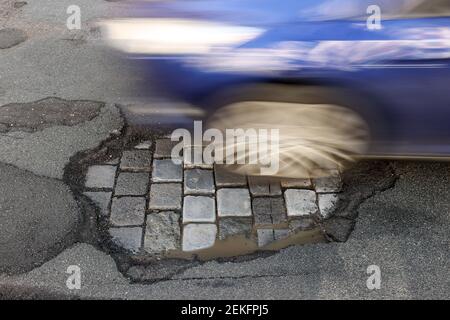 Lipsia, Germania. 19 Feb 2021. Un'auto guida su una strada con buche. Come in ogni inverno, le strade sono particolarmente colpite dall'alternanza di gelo e scongelamento. Credit: Jan Woitas/dpa-Zentralbild/ZB/dpa/Alamy Live News Foto Stock