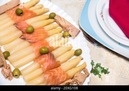 insalata di asparagi bianchi con salmone, olive e tonno su piatto bianco Foto Stock