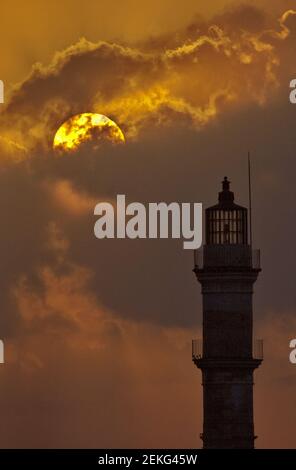 Primo piano del faro di Chania in silhouette al tramonto. La posizione è sull'isola greca di Creta. Monument è uno dei fari più antichi del mondo. Foto Stock