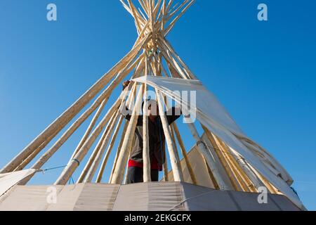 Uomo indigeno che costruisce una teepee, Quebec del Nord, Canada Foto Stock