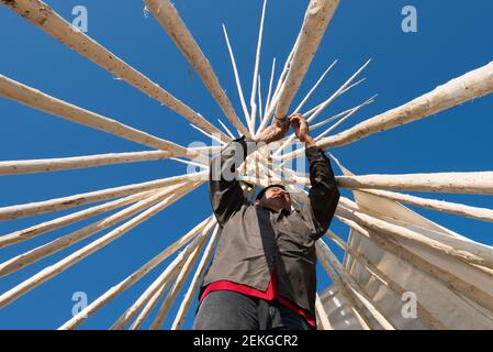 Uomo indigeno che costruisce una teepee, Quebec del Nord, Canada Foto Stock