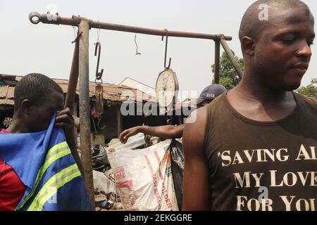 Calabar, capitale dello stato di Cross River, Nigeria. 23 febbraio 2021. Gli scavengers hanno discusso e aspettano per scalare la spazzatura. Un gruppo di vendicatori vive da una discarica di rifiuti, in un’ampia diffusione della disoccupazione in Nigeria. Foto Stock