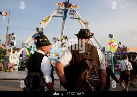 Germania Munich Octoberfest (Oktoberfest) : due uomini anziani a Lederhosen guardare una delle giostre Foto Stock