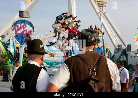 Germania Munich Octoberfest (Oktoberfest) : due uomini anziani a Lederhosen guardare una delle giostre Foto Stock