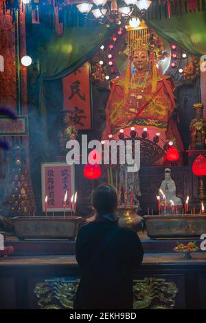 Hong Kong, Cina. Un adoratore inginocchiato di fronte alla divinità nel tempio di Tin Hau a Yau ma Tei, Kowloon. Questo tradizionale tempio cinese dove Tin Hau Foto Stock