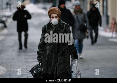 Mosca, Russia. 23 Feb 2021. Una donna che indossa una maschera cammina su una strada a Mosca, Russia, il 23 febbraio 2021. La Russia ha registrato 11,823 nuovi casi COVID-19 nelle ultime 24 ore, il numero più basso di infezioni giornaliere da ottobre, portando il numero nazionale a 4,189,153, ha detto il centro ufficiale di monitoraggio e di risposta martedì. Credit: Evgeny Sinitsyn/Xinhua/Alamy Live News Foto Stock