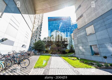 Varsavia, Polonia - 22 agosto 2018: Edifici moderni del centro con strada e vista su grattacieli di vetro blu per uffici KPMG e biciclette Foto Stock