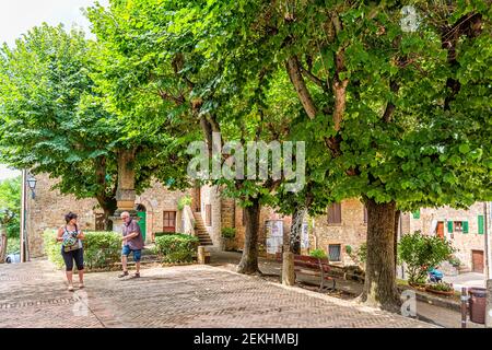 Monticchiello, Italia - 26 agosto 2018: Campagna della Val D'Orcia in Toscana con strada in piccolo villaggio con persone turisti in giardino parco in ce Foto Stock