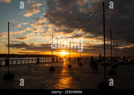 WA19339-00...WASHINGTON - sia i residenti che i turisti amano guardare il sole tramontare dal Molo 62, parte del Seattle Waterfront Park. Foto Stock