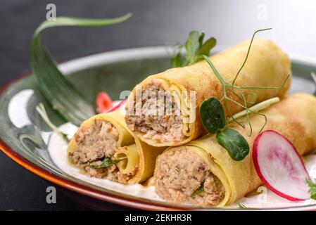 Deliziosi pancake freschi con carne su un piatto con verdure e ravanelli. Deliziosa e abbondante colazione Foto Stock