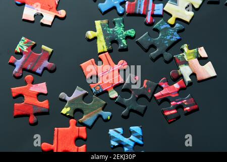 pezzi del puzzle sono sparsi sul tavolo in direzioni diverse Foto Stock