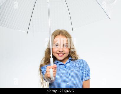 Ragazza bambino pronto incontrare il tempo di autunno con ombrello trasparente sfondo bianco. Goditi le giornate piovose con l'accessorio ombrello. Goditi il tempo autunnale. Il miglior concetto di accessori per l'autunno. Pioggia caduta tempo piacevole. Foto Stock