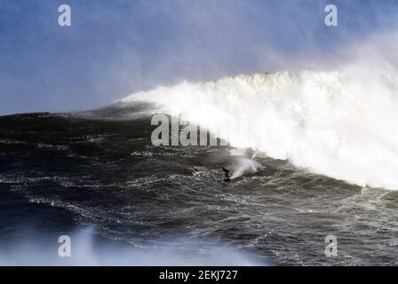 Un surfista solista gode di una grande potenza d'onda in Portogallo. Foto Stock