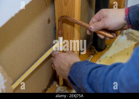 Manutenzione idraulico servizio sotto casa bagno in riparazione di plastica tubi dell'acqua in polipropilene nella parete del foro soft focus Foto Stock