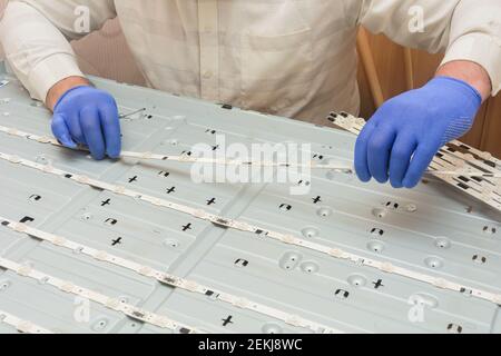 Riparazione della TV LCD. Sostituzione delle camere LED sul pannello monitor di grandi dimensioni del centro di assistenza. Foto Stock