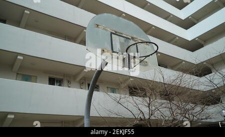 Rusty e Old Basketball Hoop in un complesso di appartamenti Foto Stock