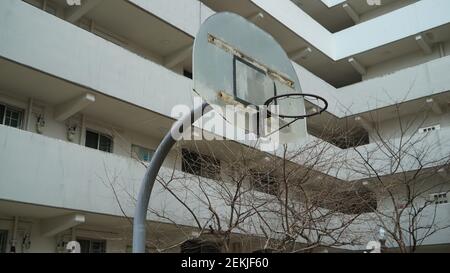 Rusty e Old Basketball Hoop in un complesso di appartamenti Foto Stock