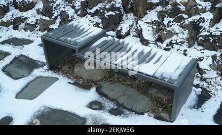 Panchine in legno innevato sul sentiero escursionistico del Winter Park Foto Stock