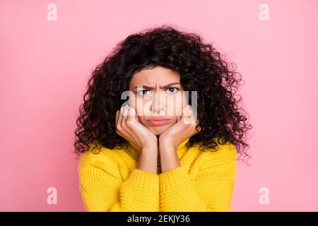 Ritratto di moody grumpy depressa ragazza riccia acconciatura isolata su sfondo rosa pastello Foto Stock