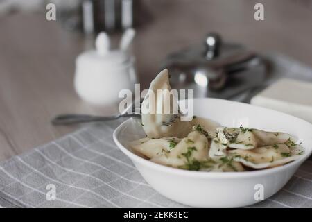 Gnocchi, ripieni di patate e serviti con burro e finocchio. Varenyky, vareniki, pierogi, pirohy. Gnocchi con riempimento. Foto Stock