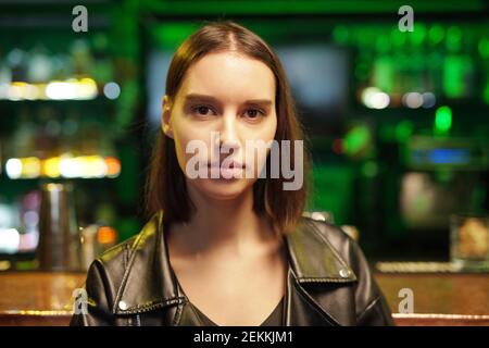 Ritratto di giovane donna che guarda la fotocamera mentre si è in piedi il pub Foto Stock