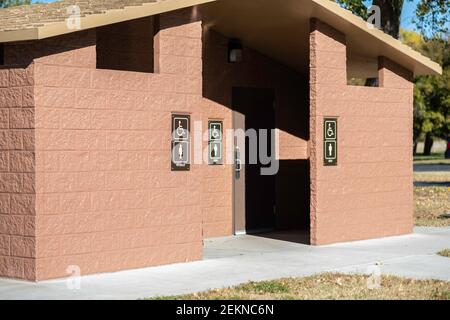 Un bagno pubblico in pietra situato in un parco pubblico. Dona accesso per disabili e bagni per uomini e donne. STATI UNITI. Foto Stock