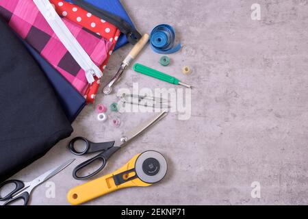 Articoli da cucire e accessori per agugliature, tessuti, fili, forbici, clasp, taglierina, metro a nastro, su sfondo grigio Foto Stock