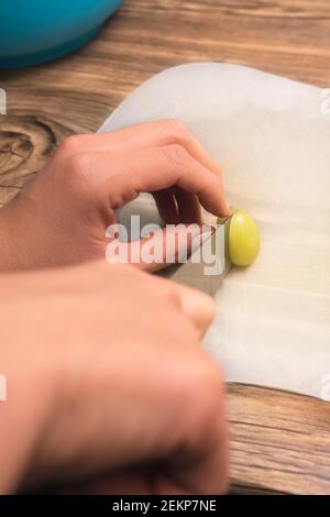 closeup di mani su ragazza latina taglio di uve verdi Foto Stock