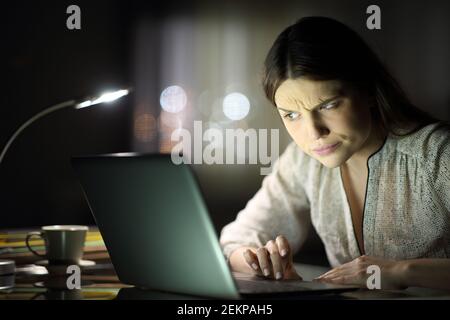 Donna imprenditore sospetta che controlla i contenuti dei notebook in tarda ora notte a casa Foto Stock