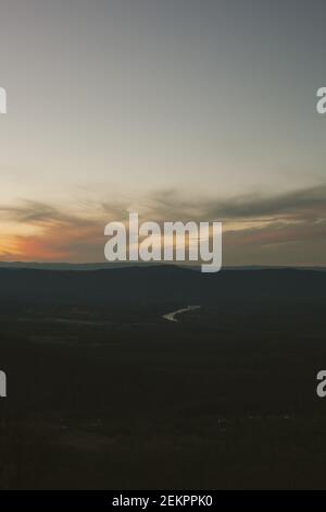 Il sole tramonta dietro le nuvole che si affacciano sul fiume Shenandoah In Virginia durante una serata autunnale Foto Stock