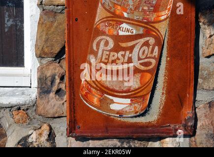 Un cartello pubblicitario arrugginito di Pepsi-Cola pende sulla parete esterna dell'ex caffetteria e stazione di servizio nel villaggio di Spencer, Missouri della Route 66. Foto Stock