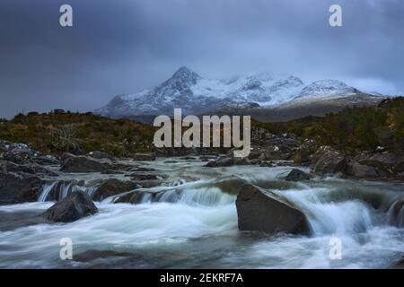 Cielo spettacolare su grandi montagne dal fiume Sligachan ON L'Isola di Skye Scozia con la catena montuosa di Cuillin in lontananza con neve in w Foto Stock