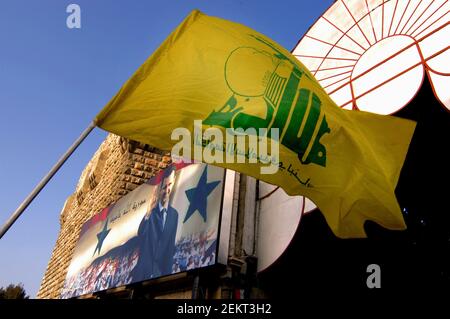 Bandiera di Hezbollah e un manifesto di Bashar al Assad visto al souk di Hamadiyya a Damasco. Foto Stock