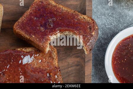 Una fetta di pane marrone con marmellata di fragole Foto Stock